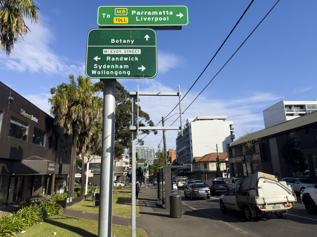 Looking south on Botany St just north of McEvoy St. Large road sign showing directions to M8.